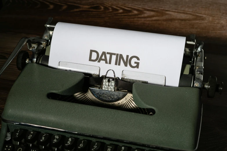 a green typewriter with the word dating written on paper