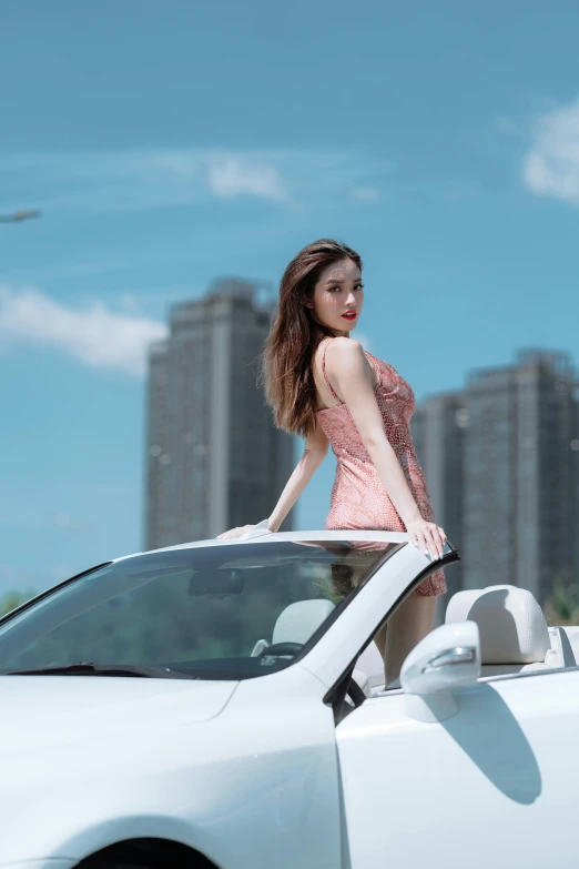 a woman standing on the roof of a car in the city