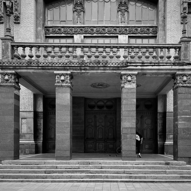 a man in a coat and suit walking on stairs