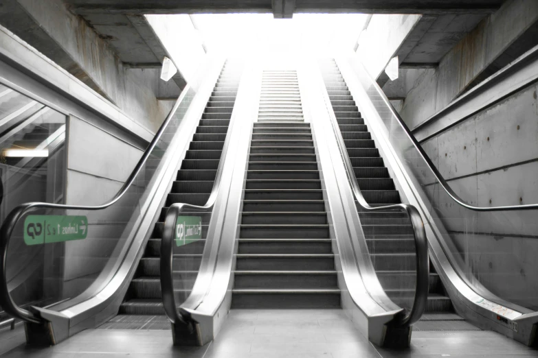 an escalator leads up to a skylight in the subway