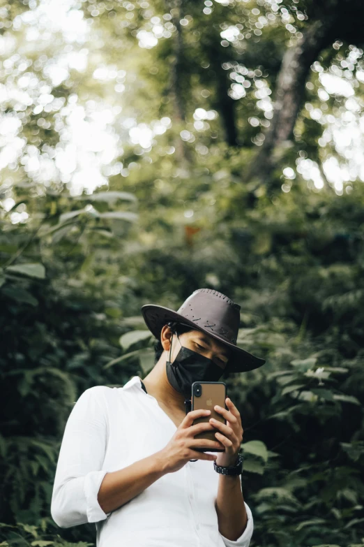 a woman wearing a hat holds up her phone