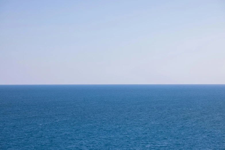 a group of people riding horseback on the shore of a blue sea