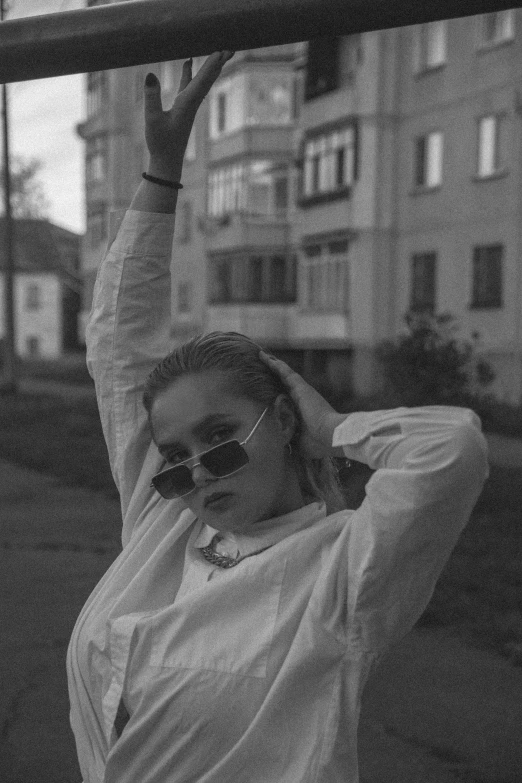 woman holding up a street sign above her head