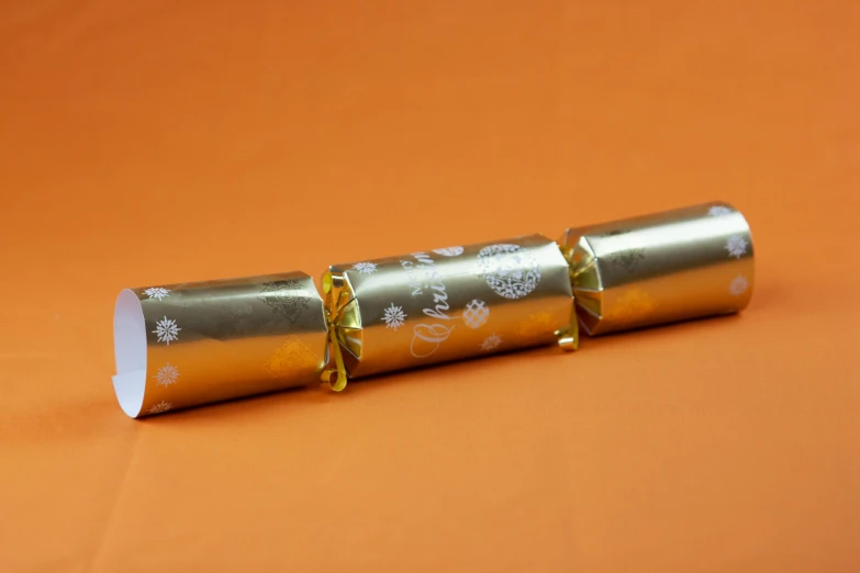 a couple of metallic tubes sitting on top of an orange table
