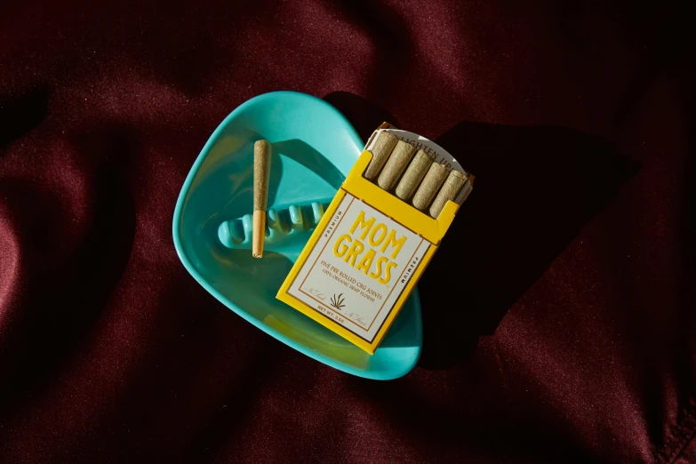 cigarettes and ashtrays are placed in a square bowl