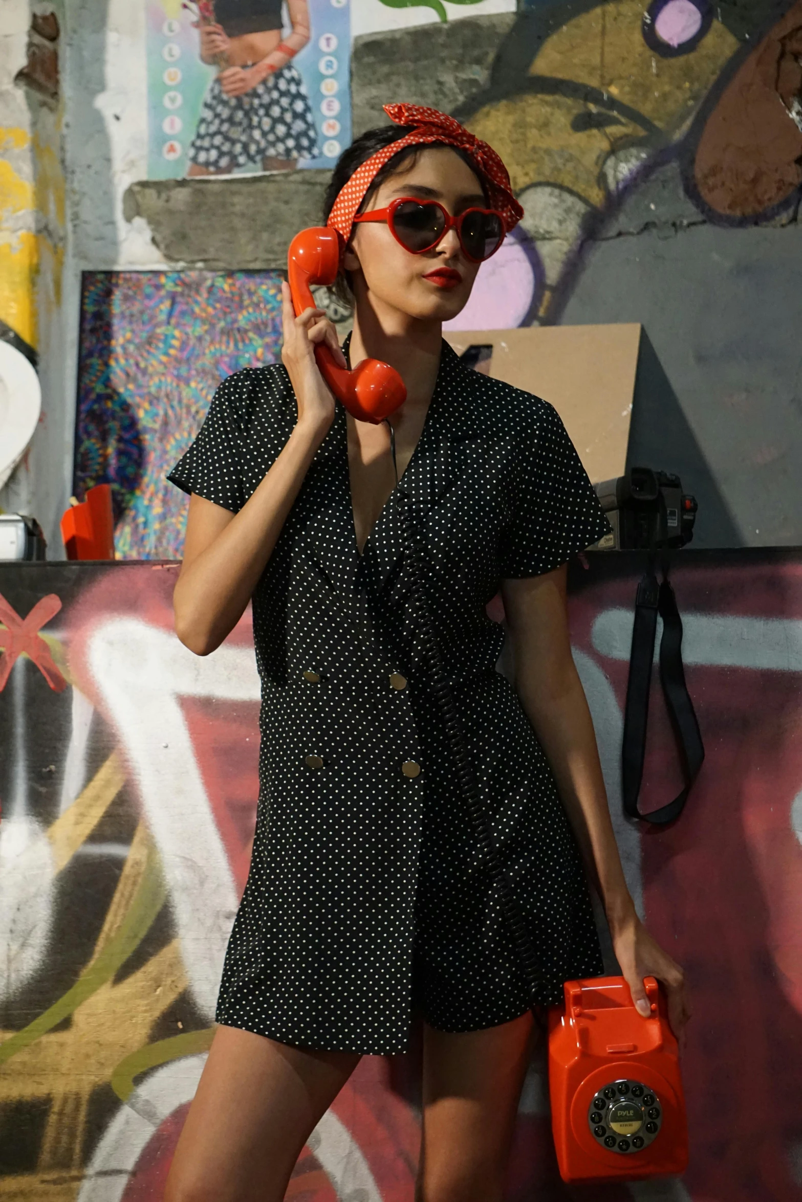 the girl in the dress is on the phone and her purse is a little red