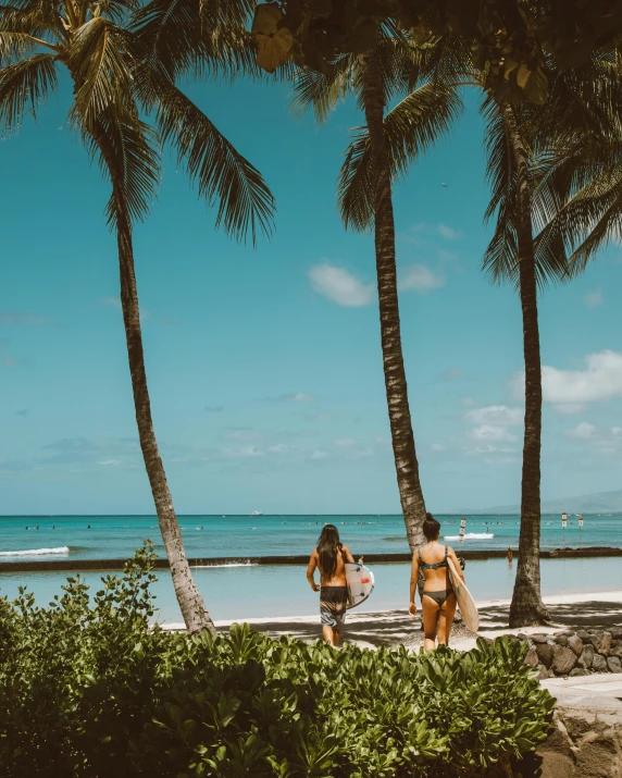 two women in bathing suits sitting on the beach