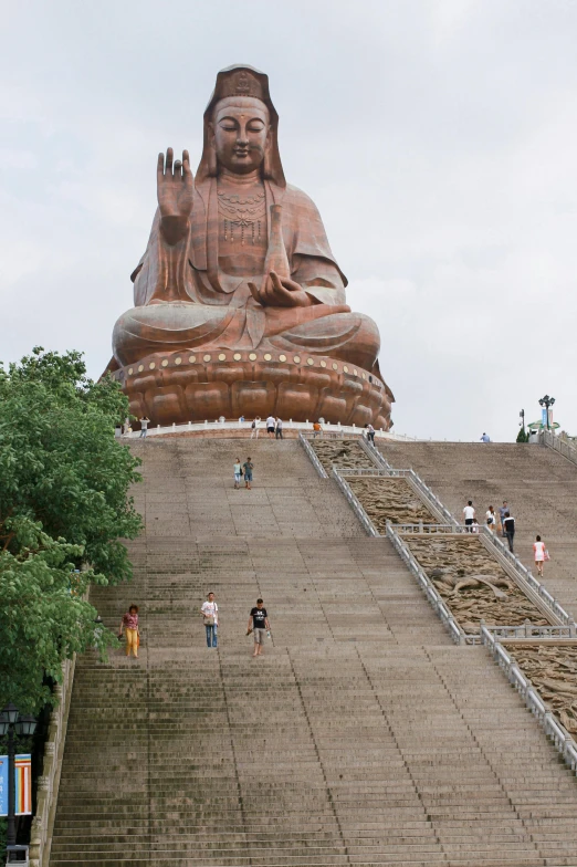 a very tall buddha statue in the middle of a bunch of steps