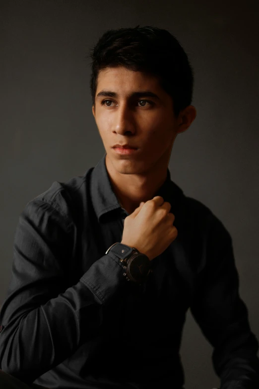a young man wearing a black shirt and celet