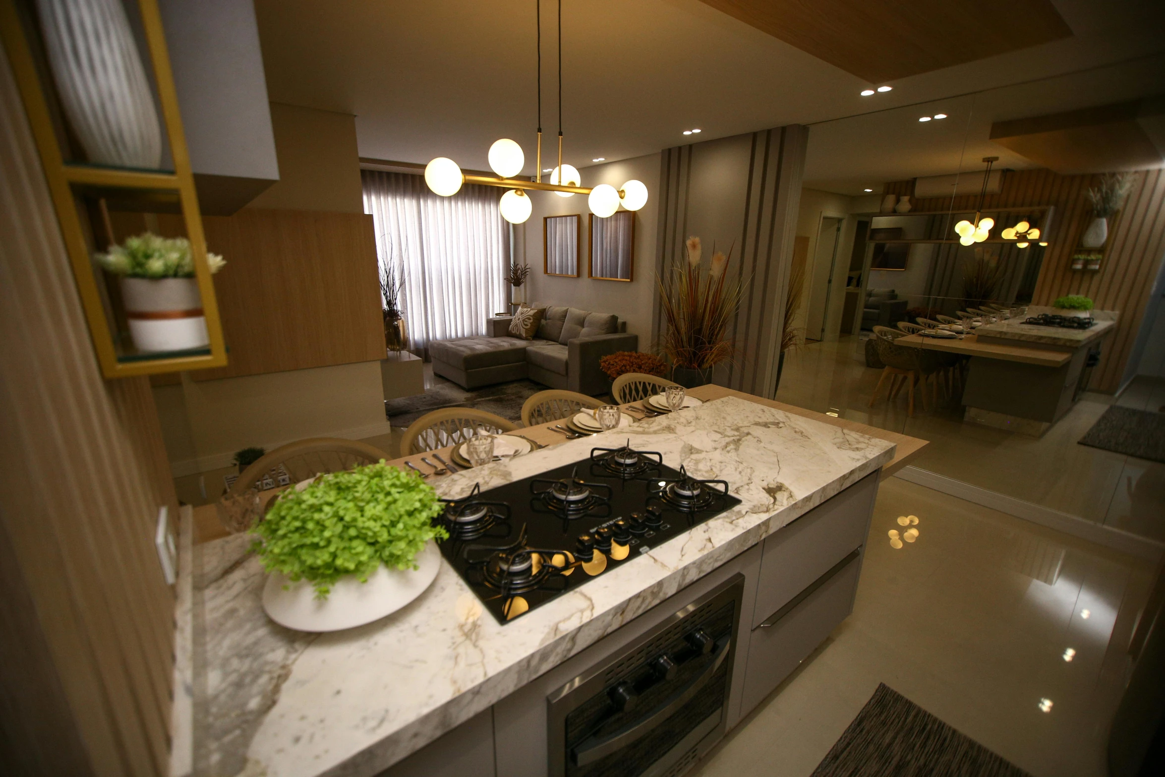 a kitchen with an open space has marble counter tops and modern lighting