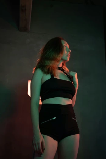 young woman posing in an empty studio wearing black underwear