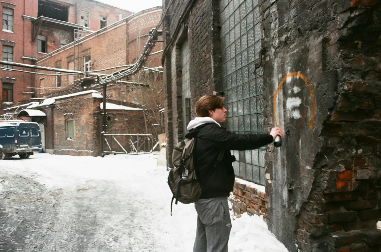 the man is looking out the window of a snowy building