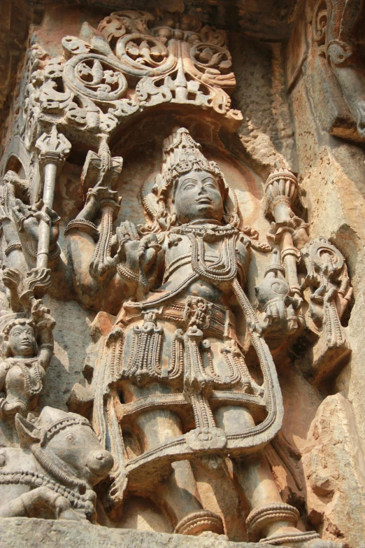 an ornate statue adorns the side of an ancient stone building