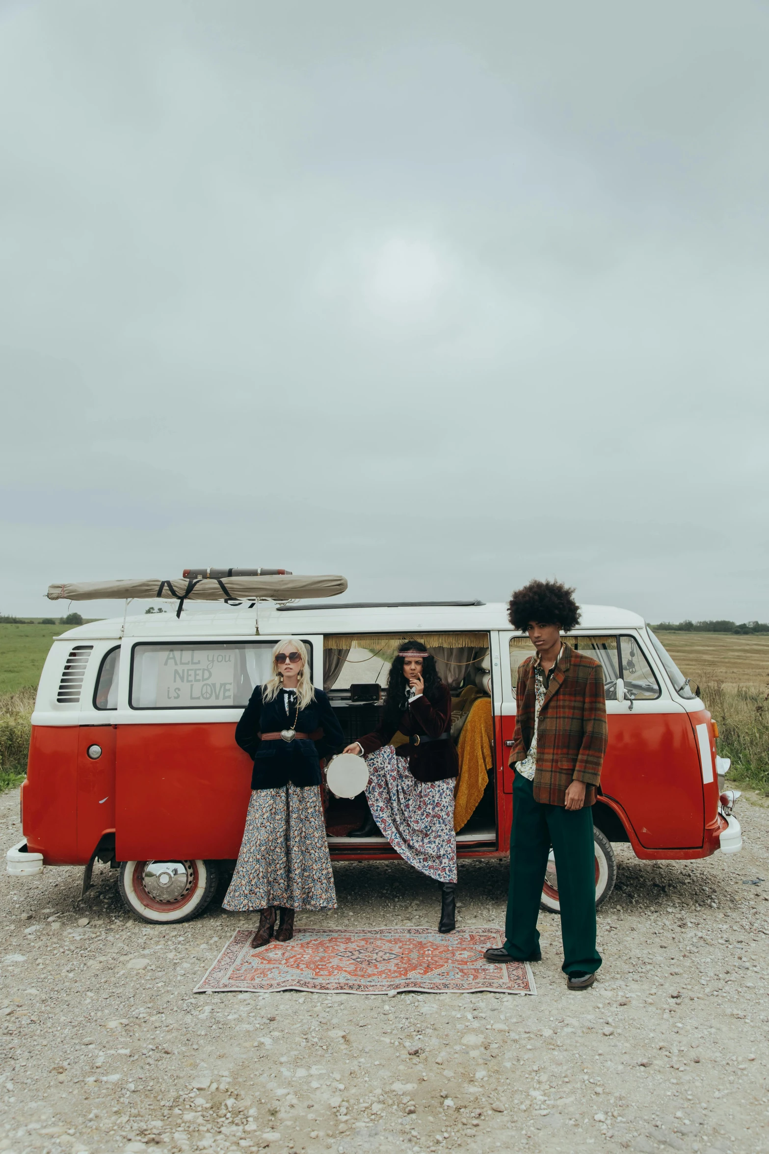 group of people standing outside an old - style van