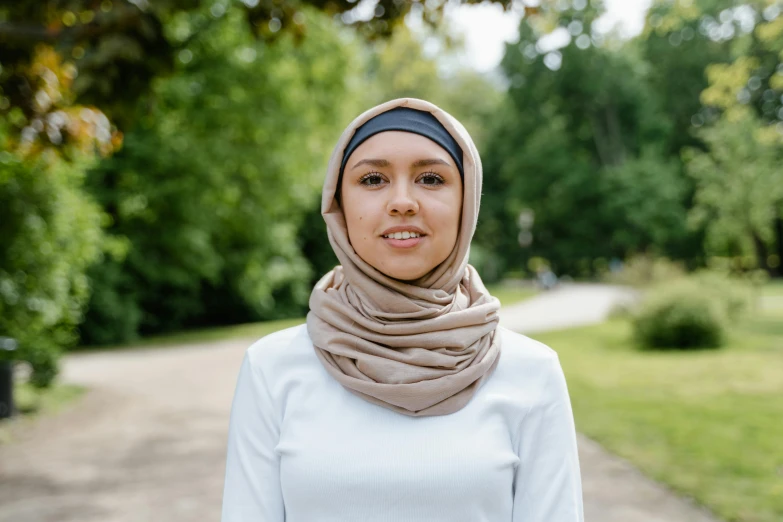 woman standing in the grass wearing a headscarf