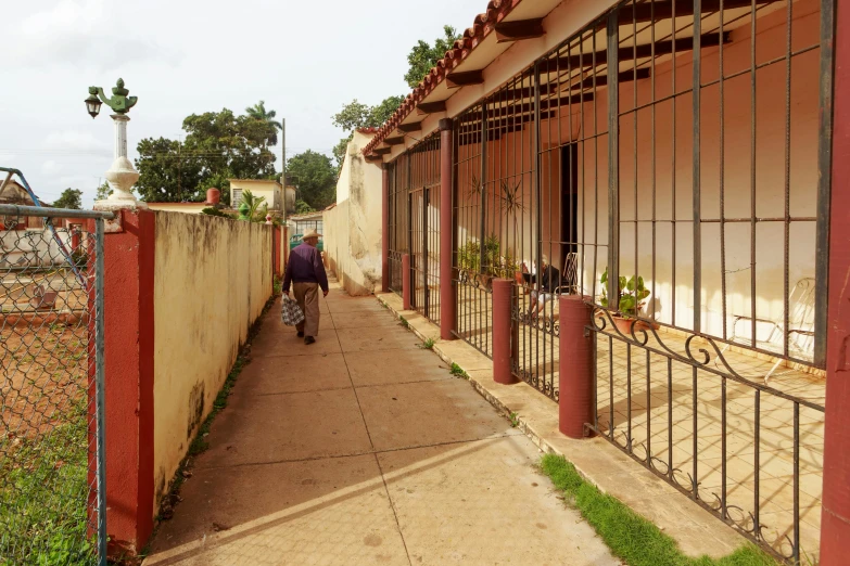 a person walking down a sidewalk in front of a building