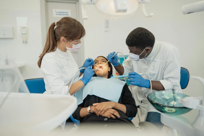 three dental care workers treat a patient for their health