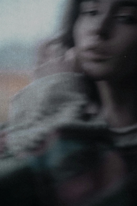 a blurry po of the face and hands of a woman