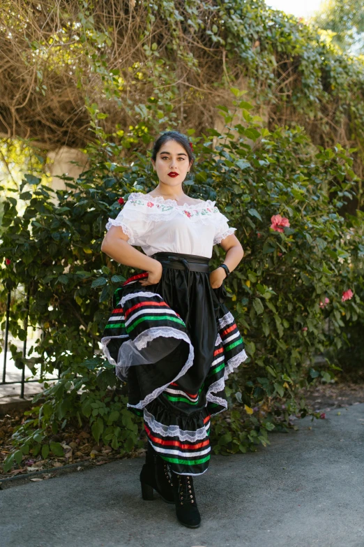 a girl dressed in an mexican outfit is posing for the camera