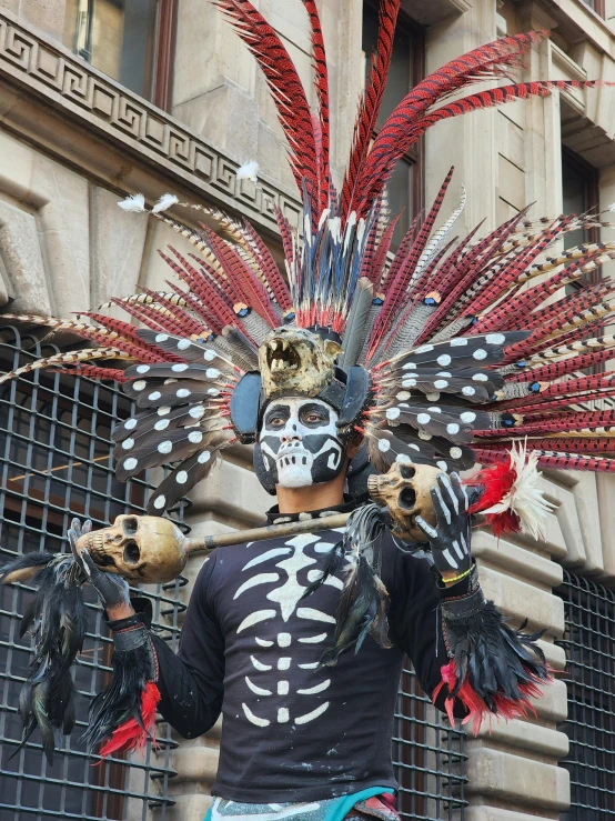 a person with a skeleton mask holding up several items