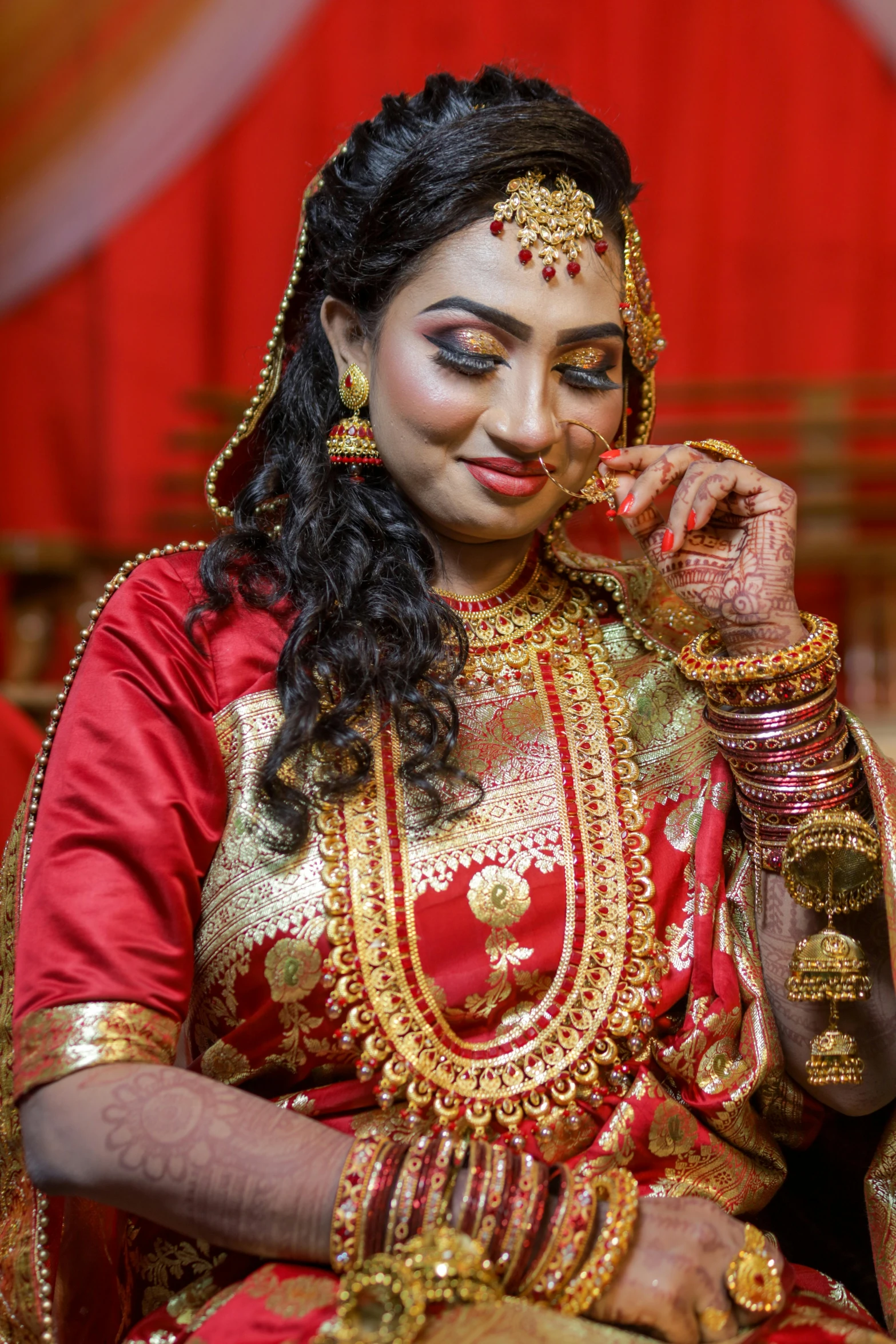 indian bride sitting down with wedding hair and makeup