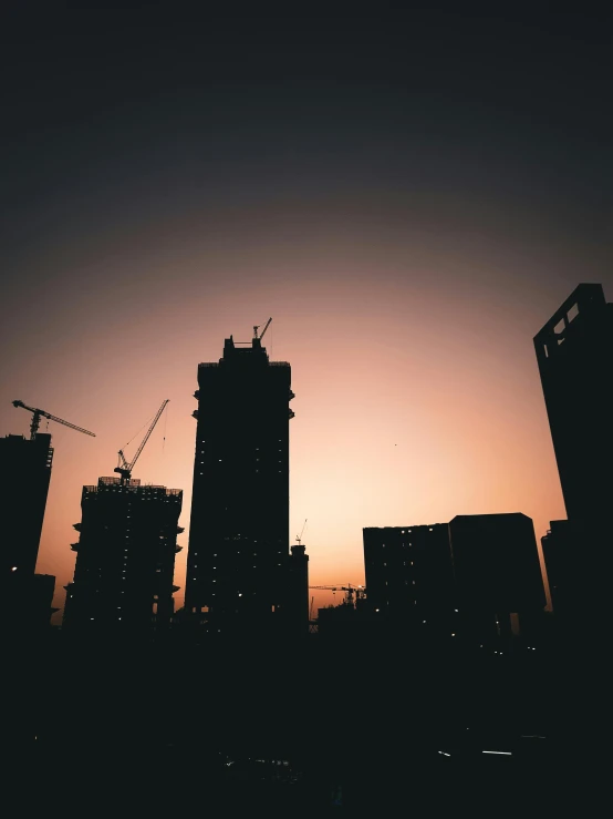 a skyline with buildings in the distance, and an orange sunset