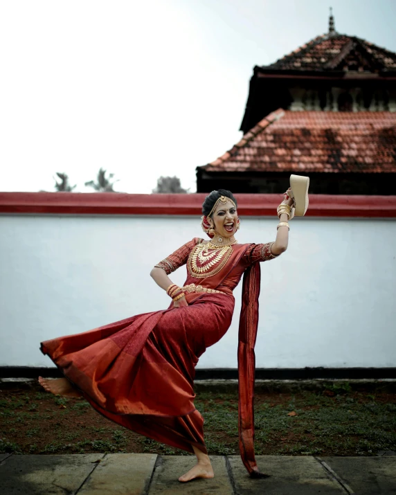 a woman dressed in a red gown holds up a pair of glasses