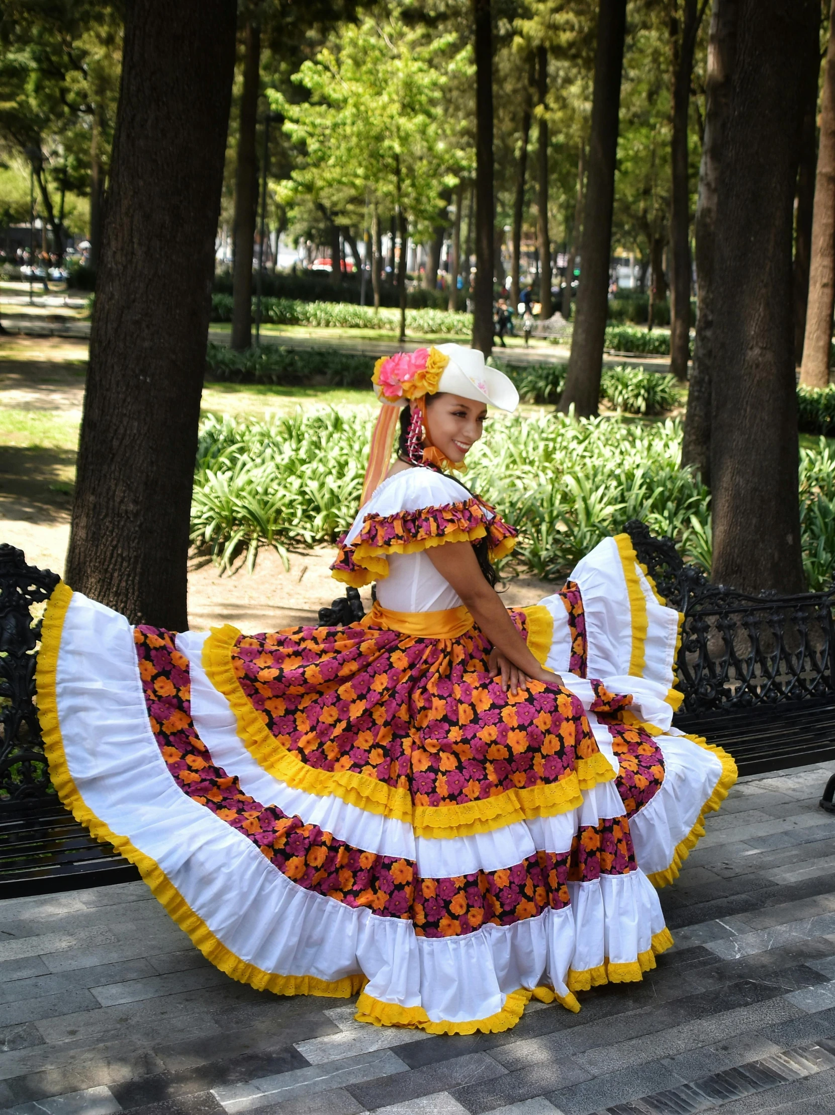 a woman in a colorful dress sitting on a bench