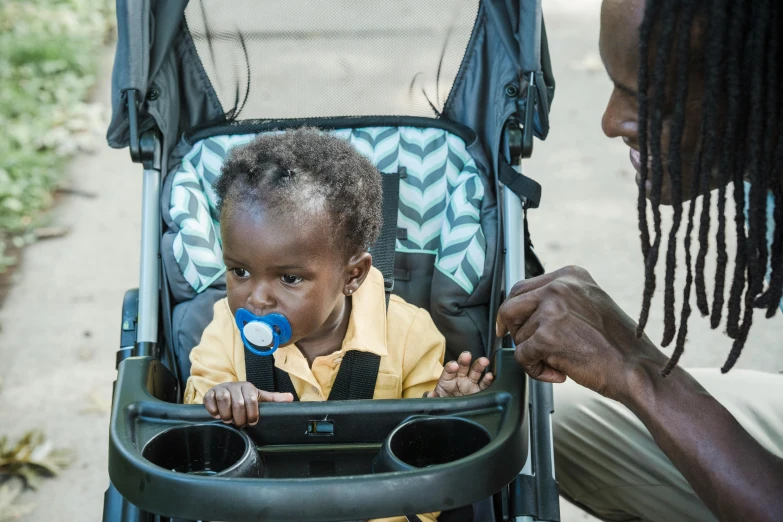 a child in a stroller is being led by an adult