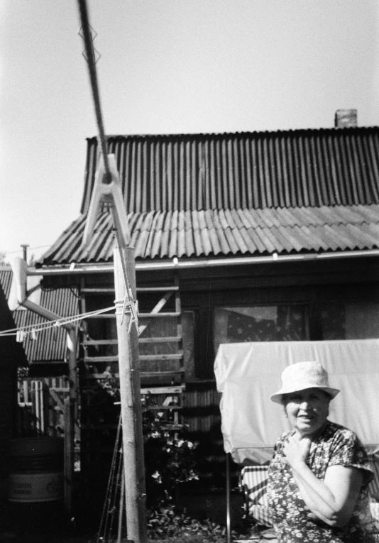 a woman sitting on a patio chair next to a building