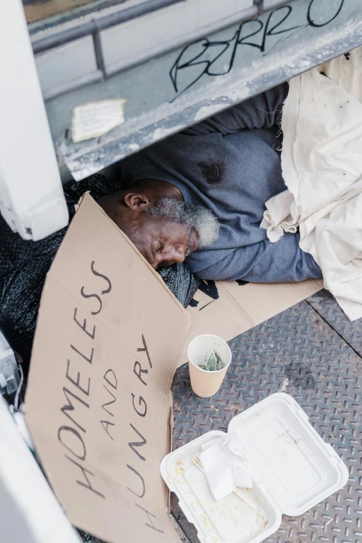 an elderly man sleeps in the back of a vehicle while eating food