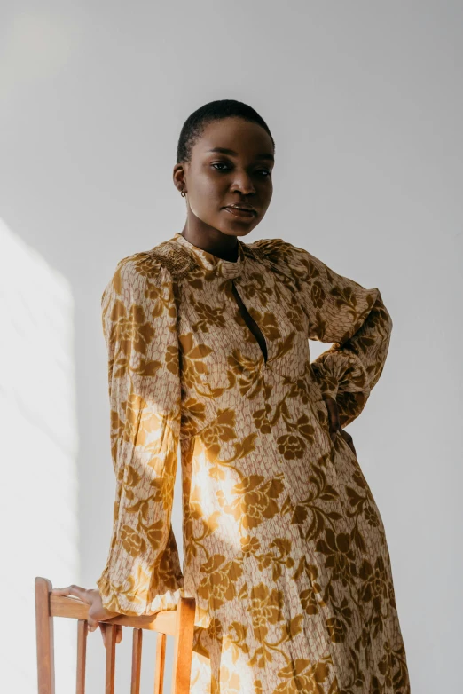 a woman in a dress poses on a chair