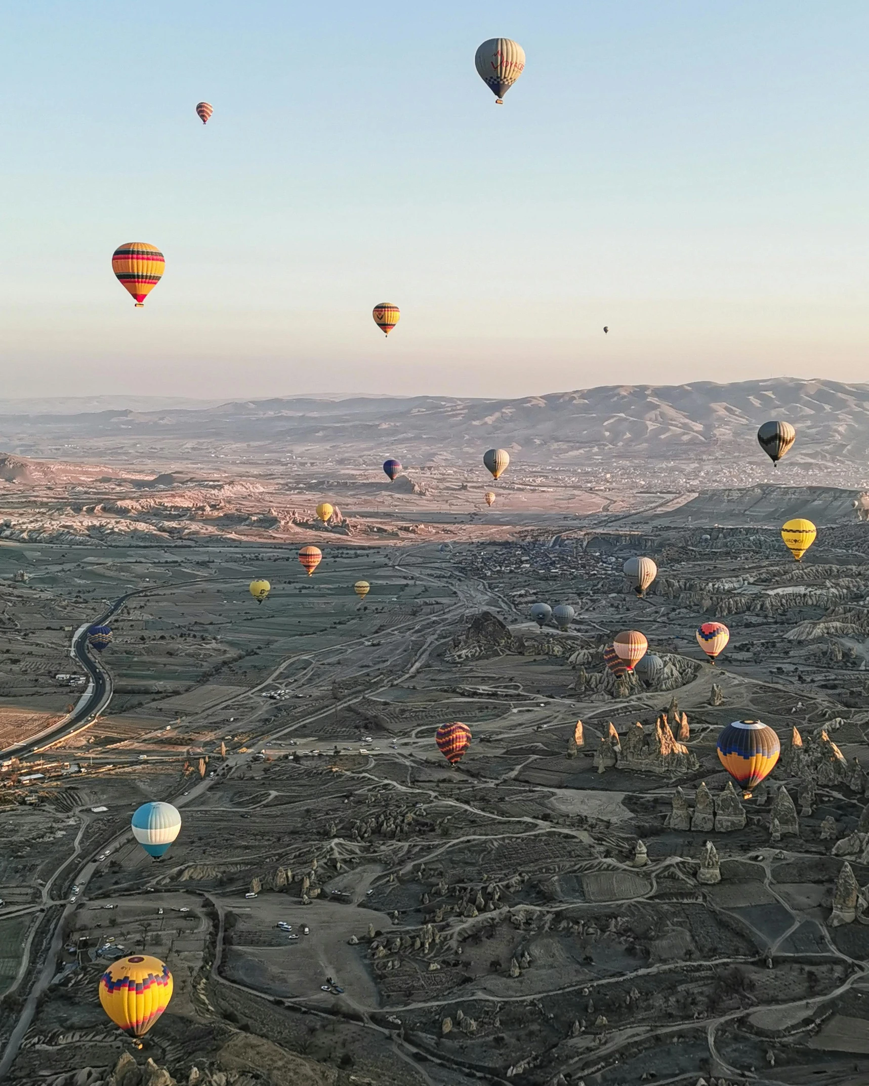 several  air balloons in the air over a town