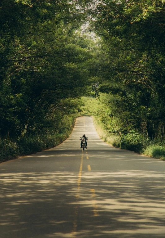 a motorcycle is traveling down an empty road