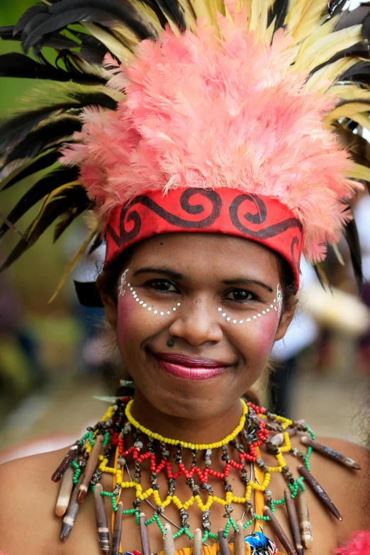 girl with feather headdress and painted face smiling