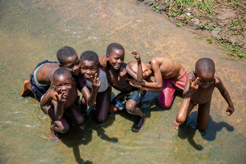 a group of boys standing in the middle of the water