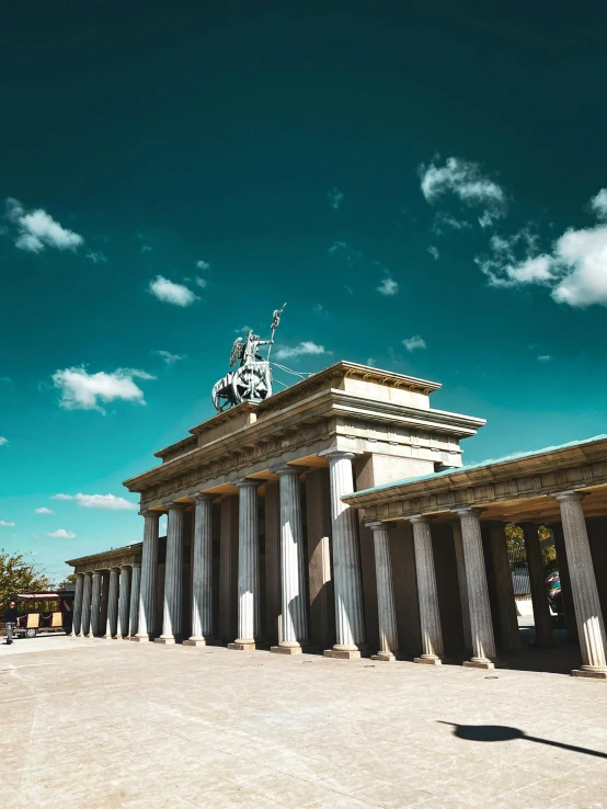 some large columns and a small building with a clock tower