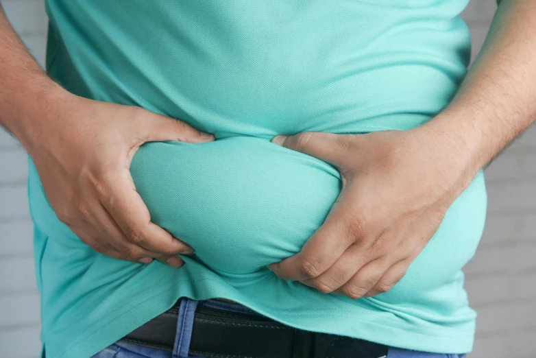 man clutching back against hips with a painous substance on his stomach