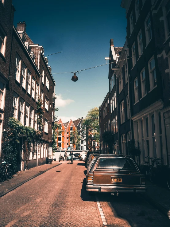 an old car on the street between some buildings