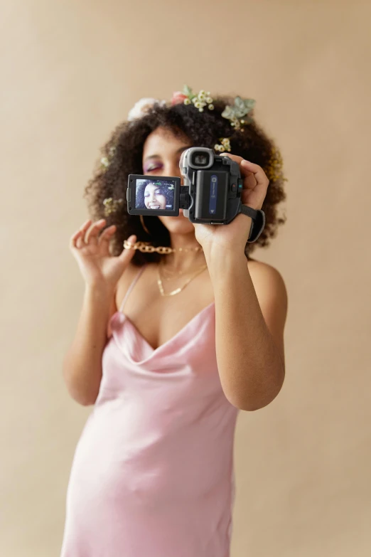 a woman standing holding up two cameras to her face