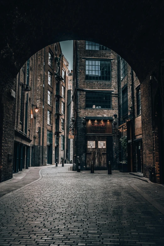 a city street has a bricked building and brick archway