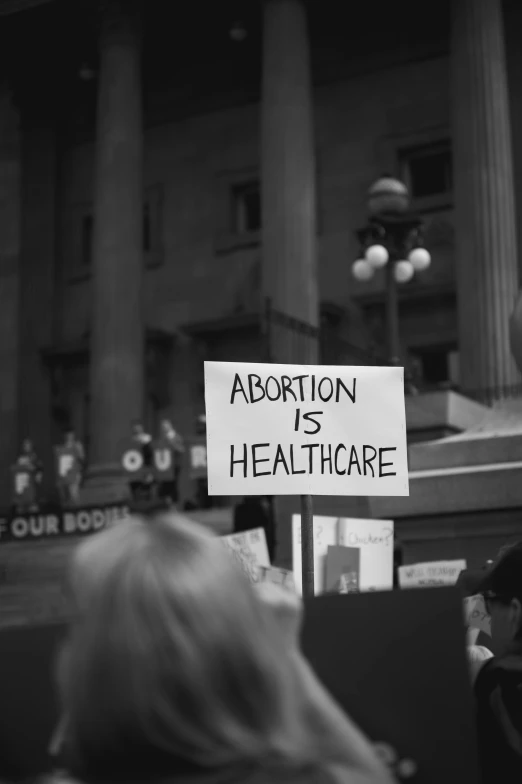 a protest for abortion is shown as people sit outside the court