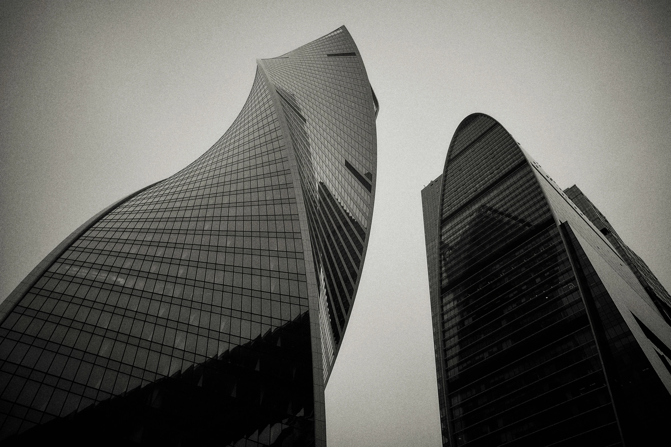 two skyscrs in front of the sky on a cloudy day