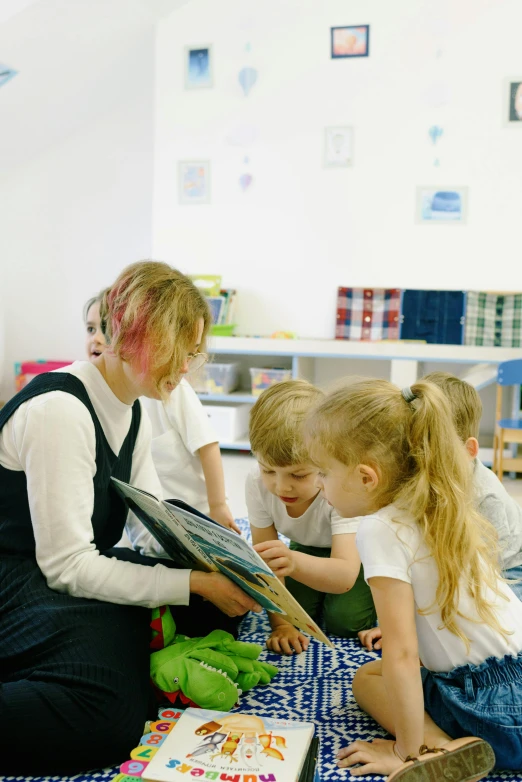 a teacher shows two children how to put on shoes