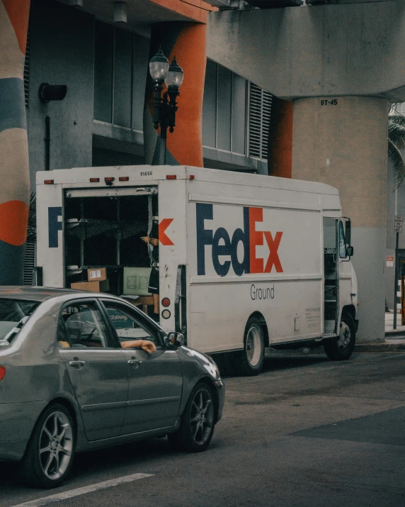 a fedex delivery truck parked next to a curb