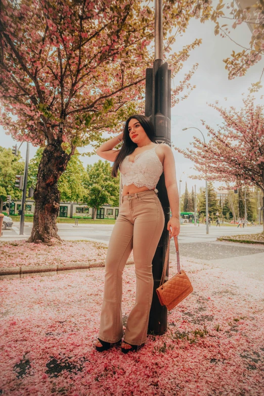 a woman is standing by a post under the trees