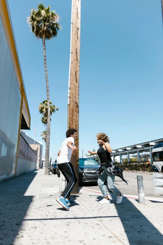 one skateboarder is jumping and another is riding a skateboard