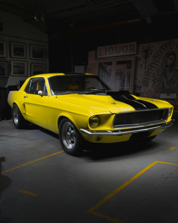 a yellow muscle car sitting inside of a garage