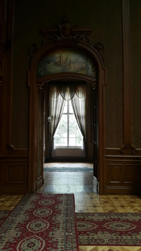 the doorway to the bedroom is flanked by a window with curtains