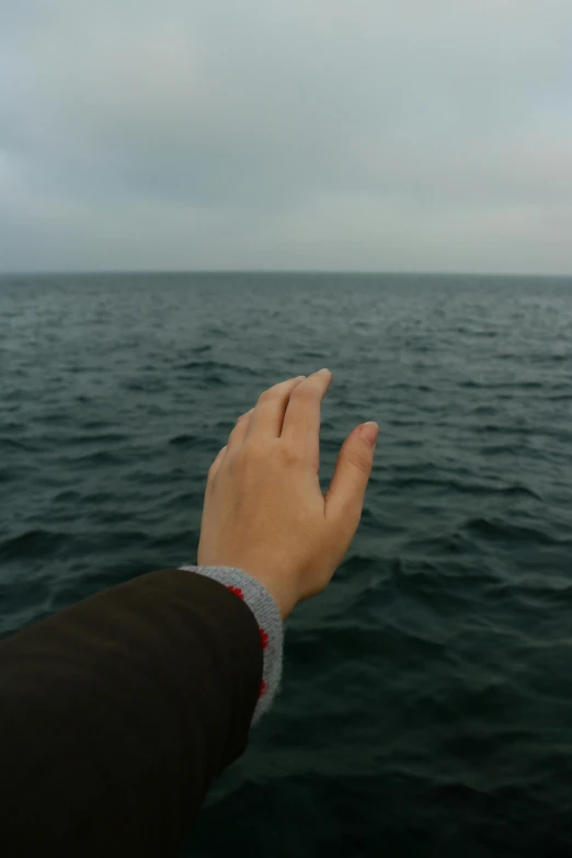 someone holding up their hand out in the ocean